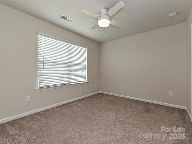 spare room with a ceiling fan, baseboards, visible vents, and carpet flooring