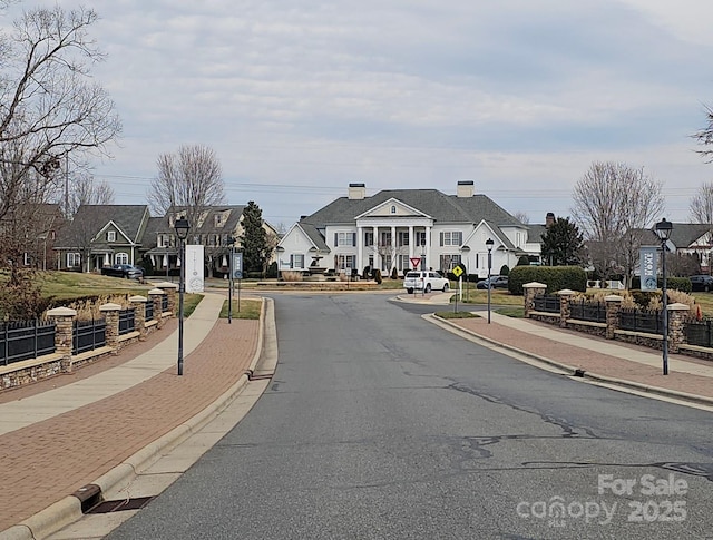 view of road with street lights, curbs, sidewalks, and a residential view