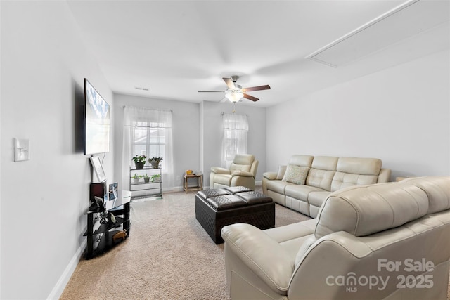 carpeted living area featuring ceiling fan, attic access, and baseboards