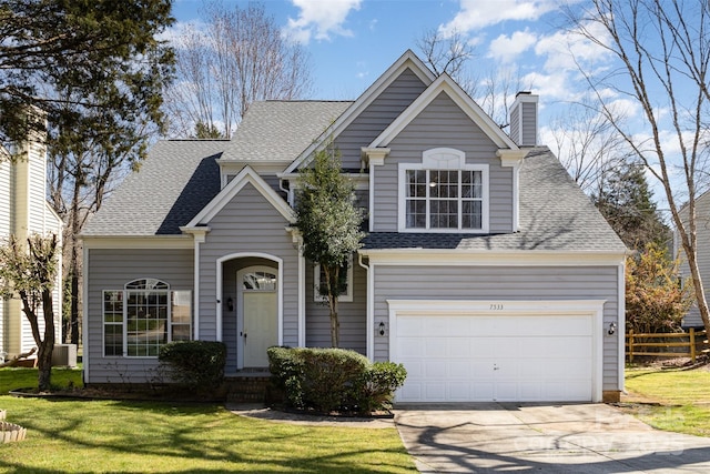 traditional-style house featuring a front yard, driveway, a chimney, a shingled roof, and central air condition unit