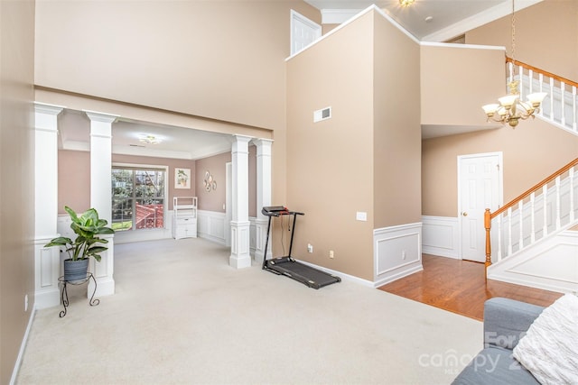 interior space featuring crown molding, carpet flooring, visible vents, and ornate columns