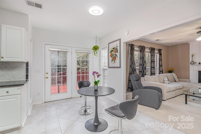 dining area with light tile patterned floors, visible vents, baseboards, and ceiling fan