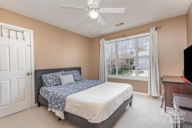 bedroom featuring visible vents, multiple windows, a ceiling fan, and carpet