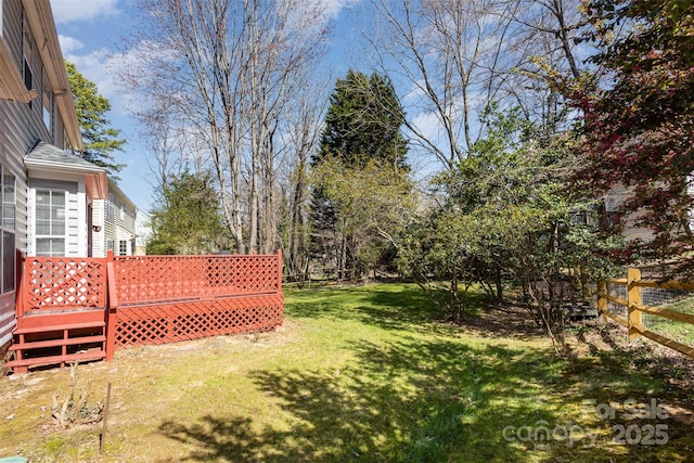 view of yard featuring a deck and fence