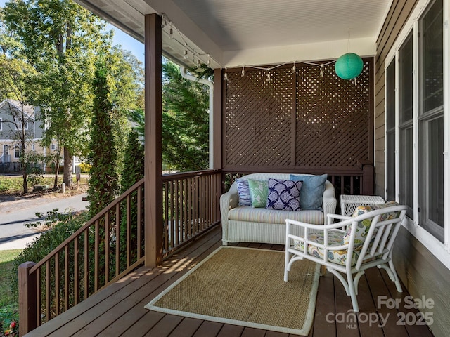 wooden terrace featuring covered porch and an outdoor hangout area