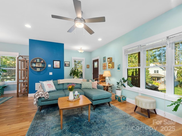 living room featuring recessed lighting, a healthy amount of sunlight, baseboards, and wood finished floors