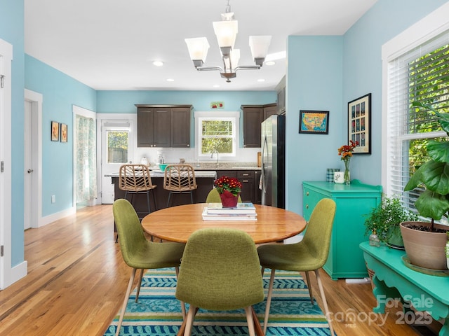 dining space featuring light wood-type flooring, baseboards, a chandelier, and recessed lighting