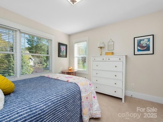 bedroom with baseboards and light colored carpet