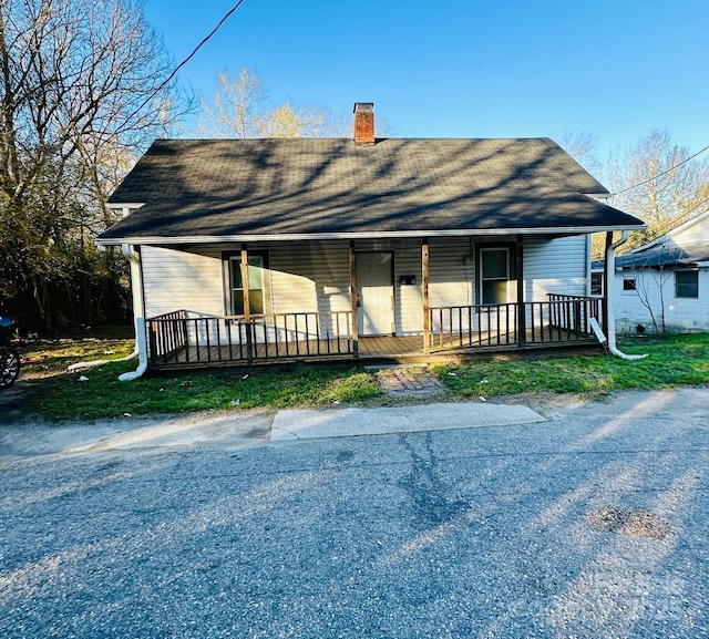 view of front facade featuring a porch and a chimney