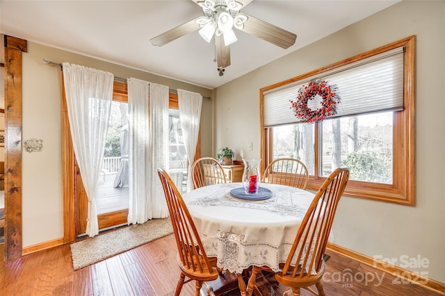 dining space with wood-type flooring, baseboards, and ceiling fan