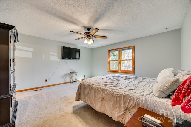 carpeted bedroom featuring a textured ceiling, ceiling fan, visible vents, and baseboards