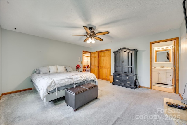 bedroom featuring light carpet, ensuite bath, a textured ceiling, and baseboards