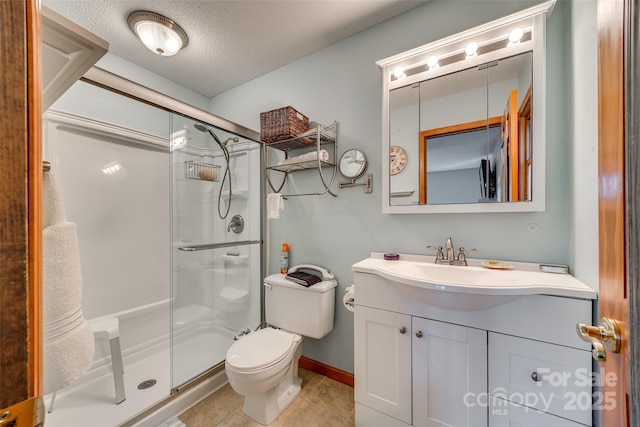 full bath with toilet, a stall shower, a textured ceiling, vanity, and tile patterned flooring