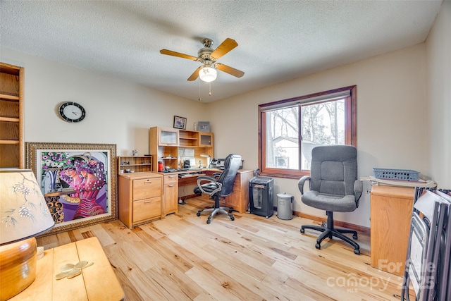 office area featuring light wood-type flooring, ceiling fan, a textured ceiling, and baseboards