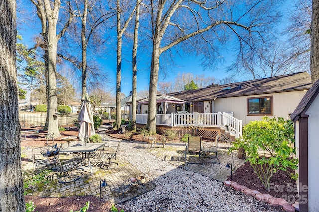 view of yard featuring a patio area, fence, and a wooden deck