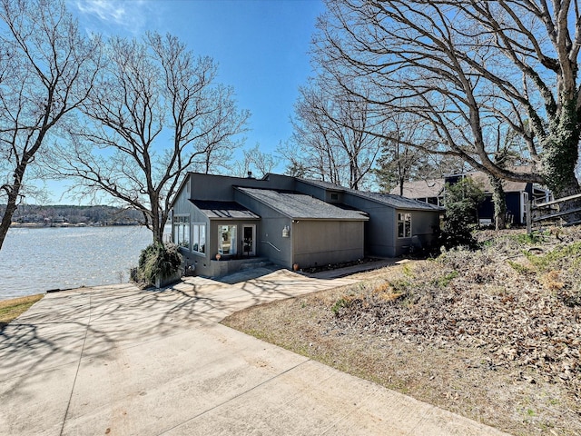 view of front facade featuring concrete driveway and a water view