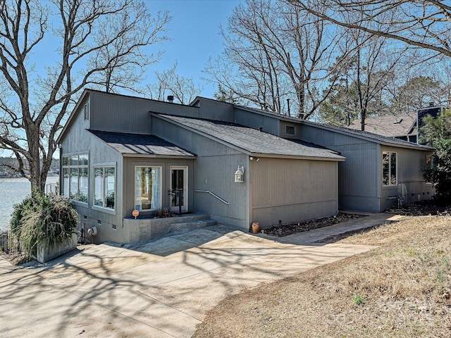 view of front of property with crawl space, a shingled roof, and concrete driveway