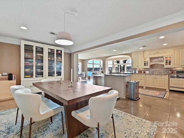 dining space featuring recessed lighting, ornamental molding, a textured ceiling, and light tile patterned flooring