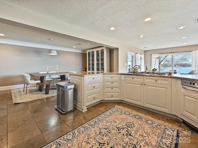 kitchen featuring baseboards, cream cabinets, light countertops, a textured ceiling, and recessed lighting