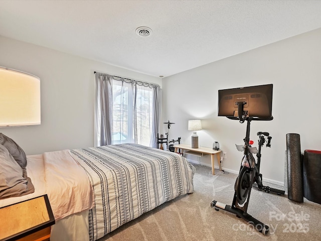 carpeted bedroom featuring a textured ceiling and baseboards