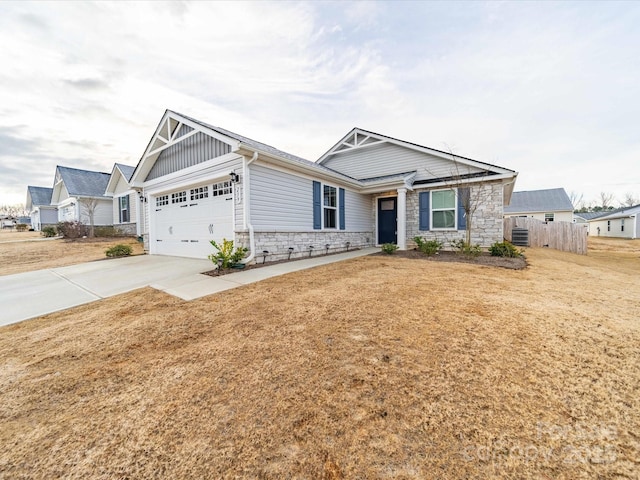 view of front of property featuring board and batten siding, concrete driveway, stone siding, and a garage