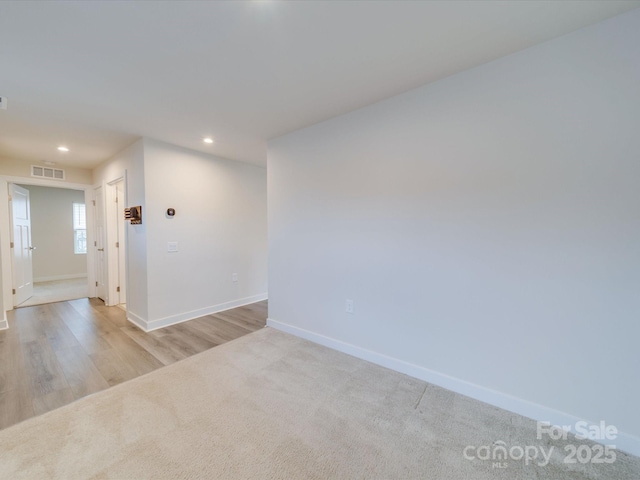 empty room featuring recessed lighting, visible vents, light carpet, and baseboards