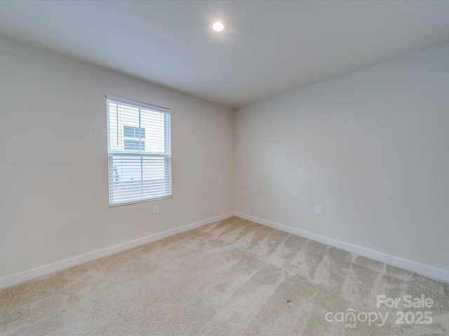 empty room with baseboards and light colored carpet