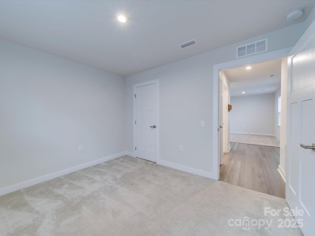 carpeted spare room with baseboards, visible vents, and recessed lighting