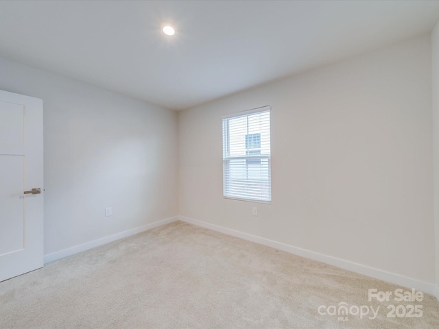 carpeted empty room featuring recessed lighting and baseboards