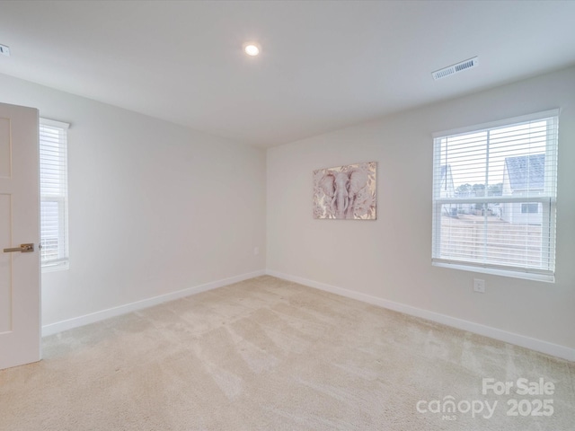 unfurnished room featuring recessed lighting, light carpet, visible vents, and baseboards