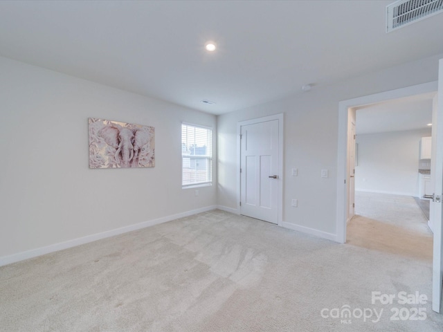 unfurnished room featuring baseboards, visible vents, carpet flooring, and recessed lighting