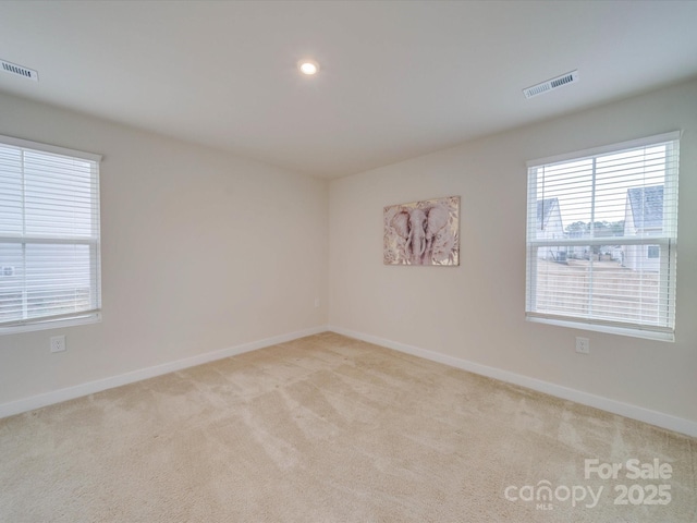 empty room with recessed lighting, visible vents, baseboards, and light colored carpet