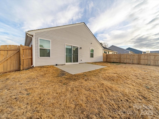 back of house with a patio area, a fenced backyard, and a lawn