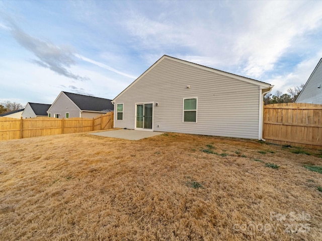 rear view of house with a lawn, a patio area, and a fenced backyard