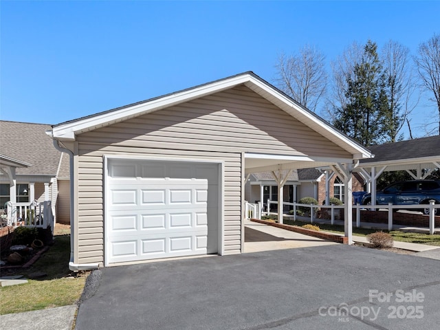 view of front of home with an outbuilding, an attached garage, fence, driveway, and a carport