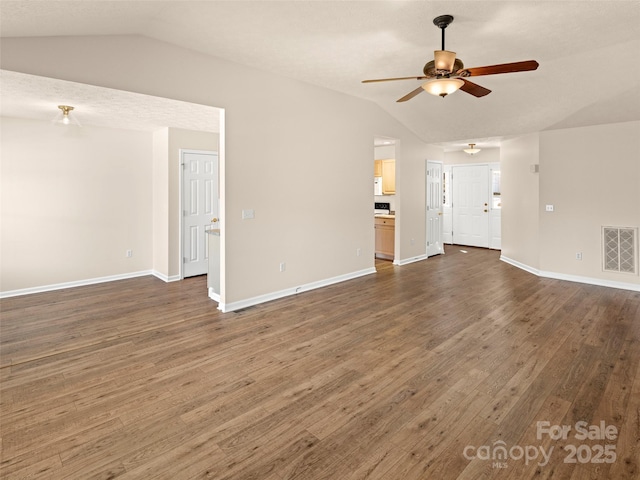 unfurnished living room with lofted ceiling, ceiling fan, dark wood finished floors, and visible vents