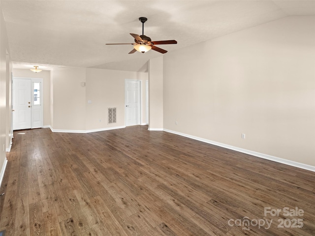 unfurnished living room featuring dark wood-style flooring, visible vents, vaulted ceiling, and baseboards