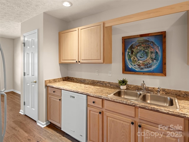 kitchen featuring light brown cabinetry, white dishwasher, a sink, and light wood-style flooring