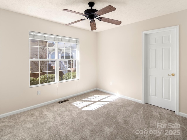 unfurnished room featuring carpet floors, baseboards, visible vents, and a textured ceiling