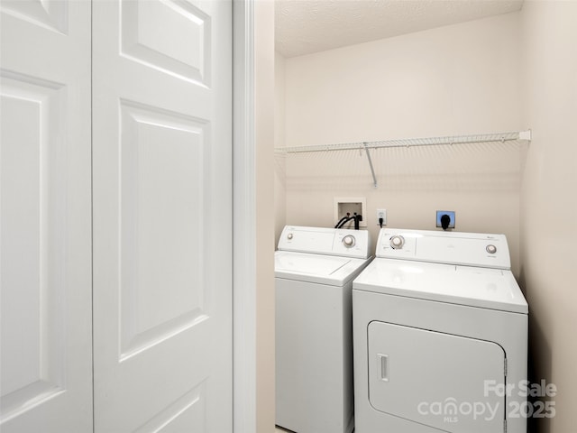 laundry area featuring laundry area, a textured ceiling, and independent washer and dryer