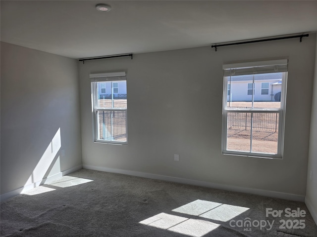 carpeted spare room with baseboards