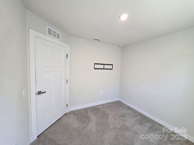 unfurnished room featuring carpet, visible vents, and baseboards