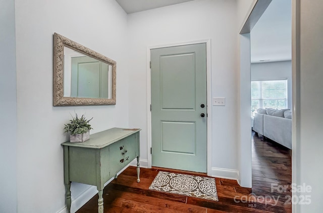 foyer featuring baseboards and wood finished floors