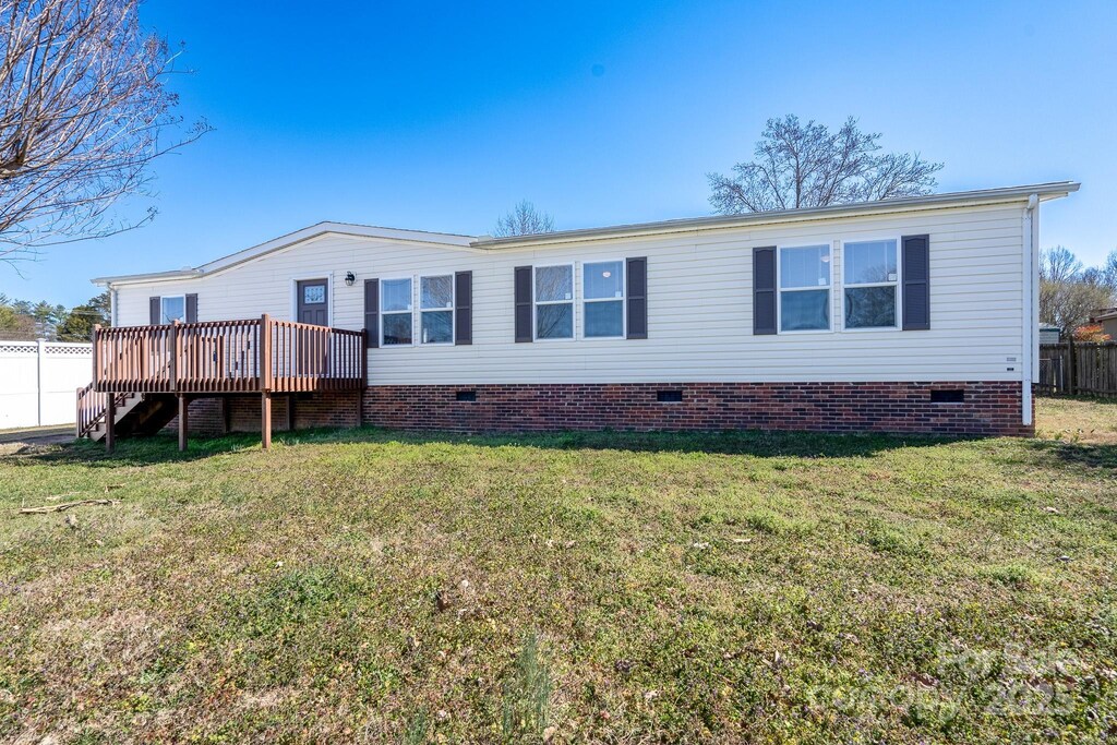 exterior space with crawl space, a wooden deck, fence, and a yard