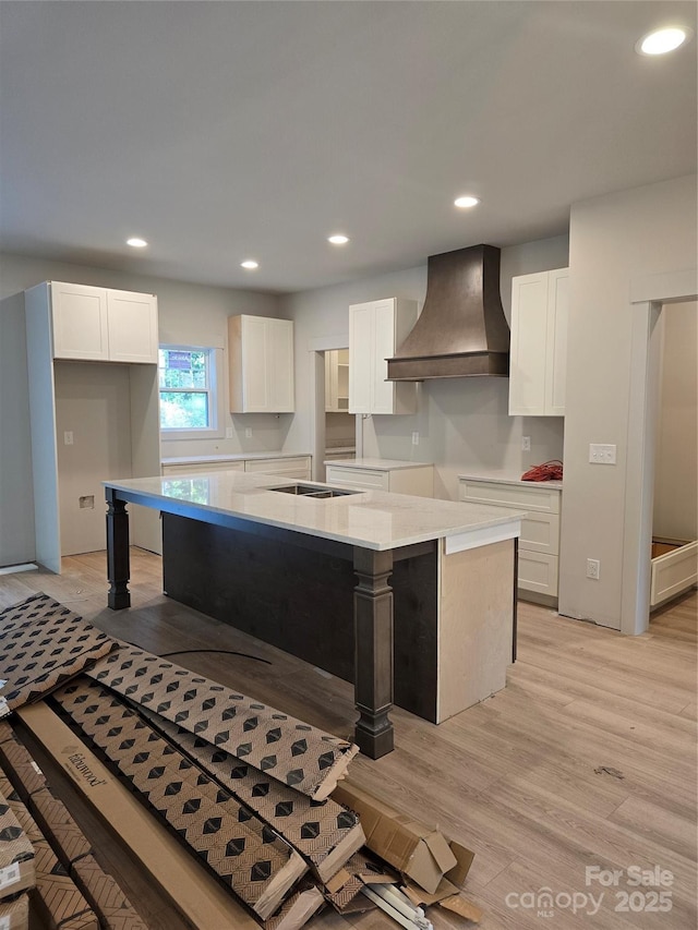 44389 US-52 Hwy N, Richfield, NC 28137 - kitchen with custom range hood, white cabinets, a kitchen island, recessed lighting, and light wood-type flooring