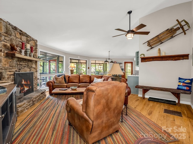 1973 Buffalo Creek Rd, Lake Lure, NC 28746 - living area with a fireplace, wood finished floors, a healthy amount of sunlight, and a ceiling fan