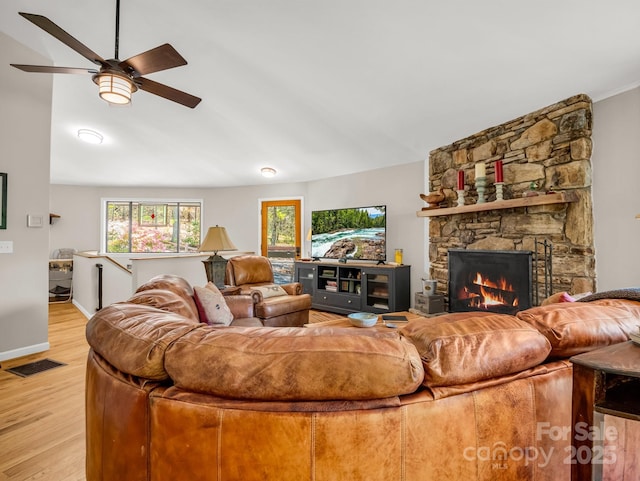 1973 Buffalo Creek Rd, Lake Lure, NC 28746 - living area with a stone fireplace, visible vents, a ceiling fan, vaulted ceiling, and light wood-style floors