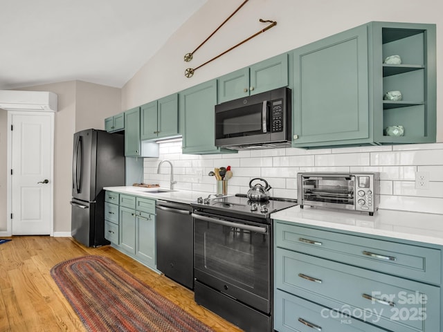 1973 Buffalo Creek Rd, Lake Lure, NC 28746 - kitchen featuring a wall mounted air conditioner, a sink, decorative backsplash, stainless steel appliances, and light countertops