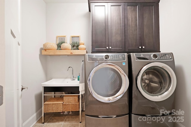 laundry area featuring cabinet space, washing machine and dryer, tile patterned flooring, and a sink