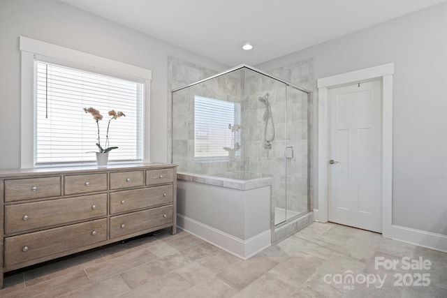 bathroom with a stall shower and baseboards